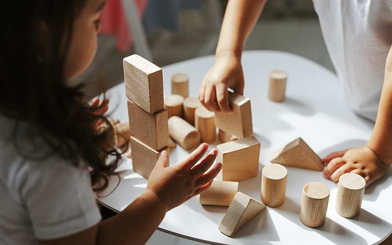children boy and girl play with wooden toys