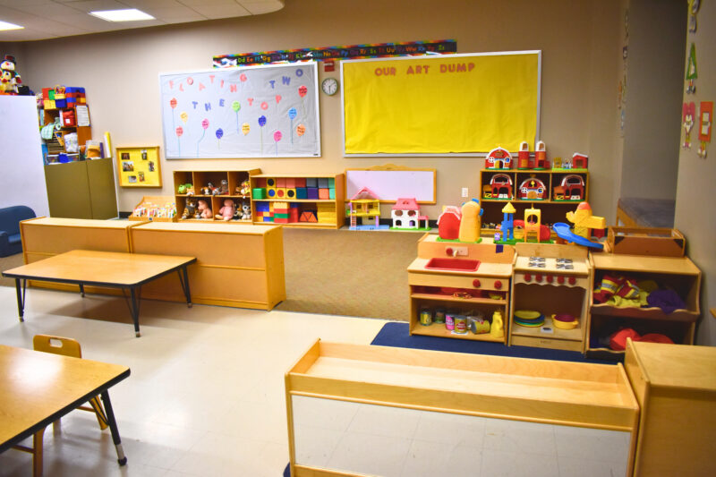 Colorful preschool classroom with tables and toys.