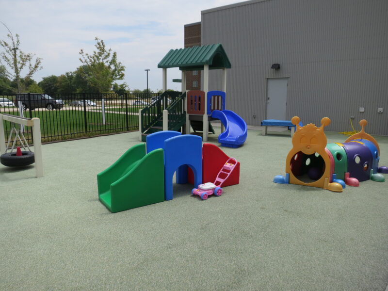 Colorful outdoor enclosed playground at KidsPoint C Street.
